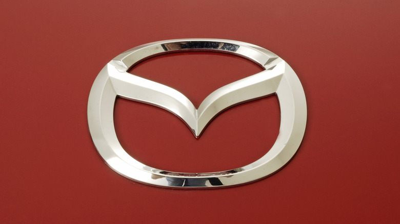 Close-up of a Mazda badge on a red car.