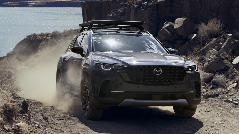 A gray Mazda CX-50 SUV being driven off-road.