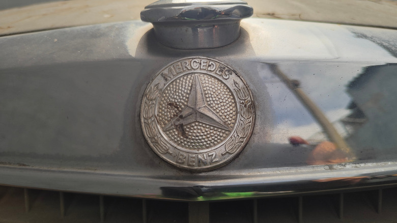 Rusted Mercedes-Benz logo on car