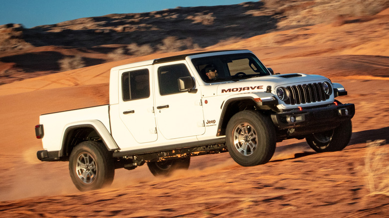 Front 3/4 view of white Jeep Gladiator on desert trail.