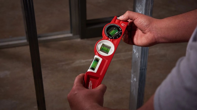 Man holding Milwaukee 10-Inch Torpedo Level
