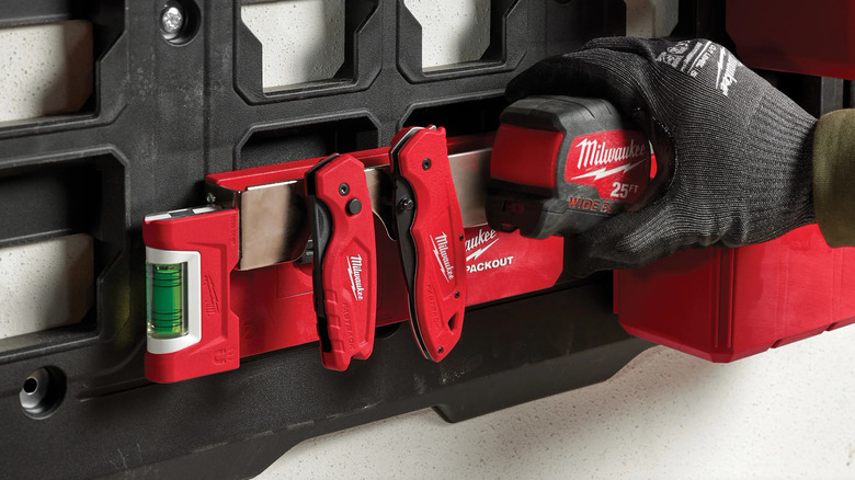 A person adding tape measure to belt clip rack