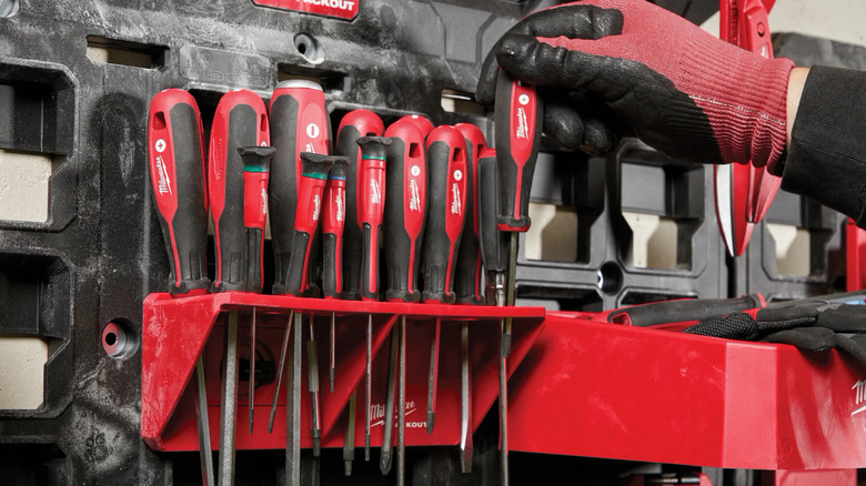 A person adding screwdriver to rack