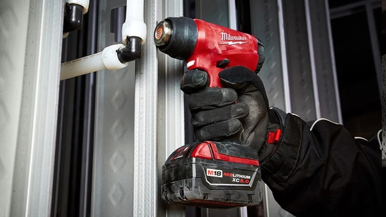 Person using Milwaukee M18 Compact Heat Gun on PVC