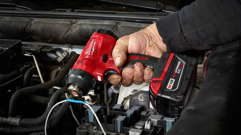 Mechanic using a Milwaukee M18 heat gun