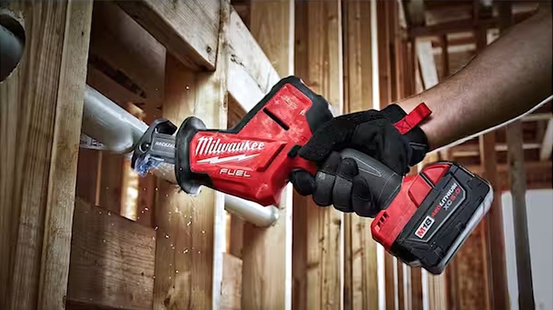Person using Milwaukee Hackzall saw to cut piping