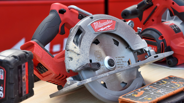 Milwaukee circular saw with sawdust on its blade sitting on table