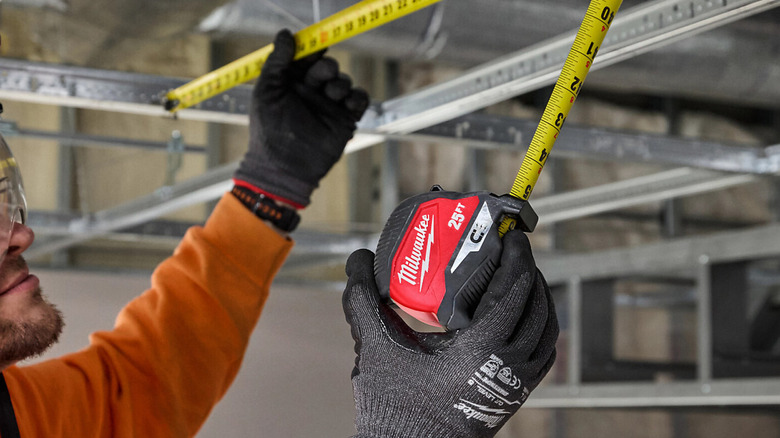 A person taking measurements with the Milwaukee 25 ft. Magnetic Tape Measure.