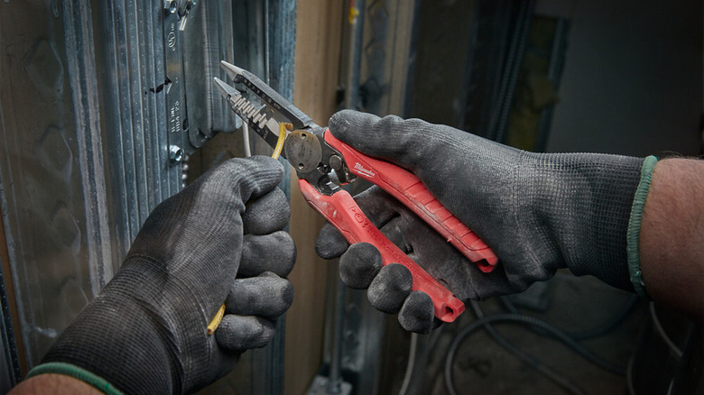 A pair of Milwaukee Combination Electricians 6-in-1 Wire Stripper/Cutter Pliers in use