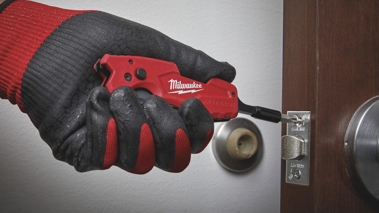 A Milwaukee Fastback 6-in-1 Folding Utility Knife used to install a door lock.