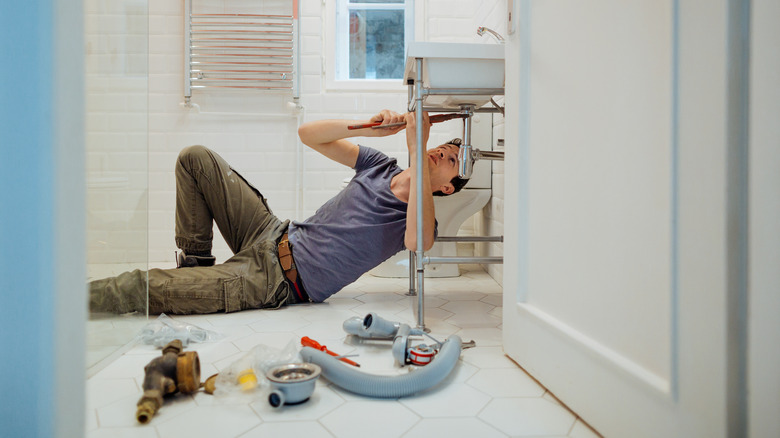 Plumber installing a sink bottle trap