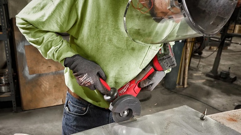 Person using Milwaukee angle grinder on table