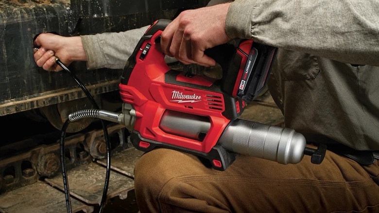Person using Milwaukee M18 Grease Gun