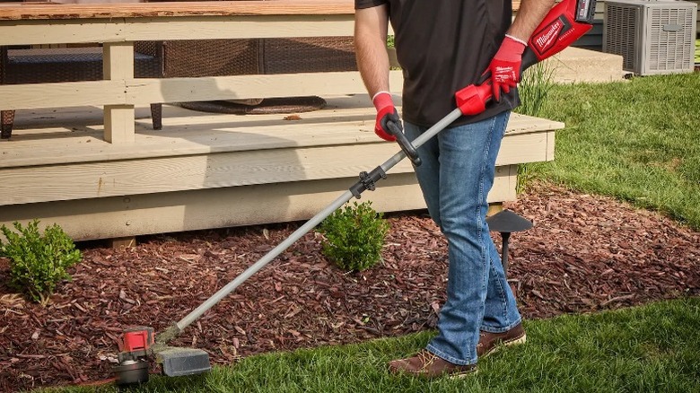 Man using a M18 Brushless String Trimmer