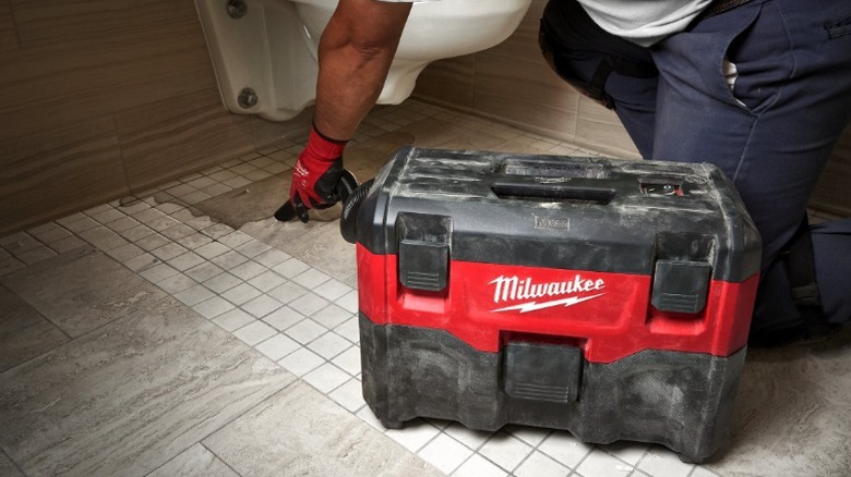 Person using Milwaukee M18 2-Gallon Wet/Dry Vacuum in toilet