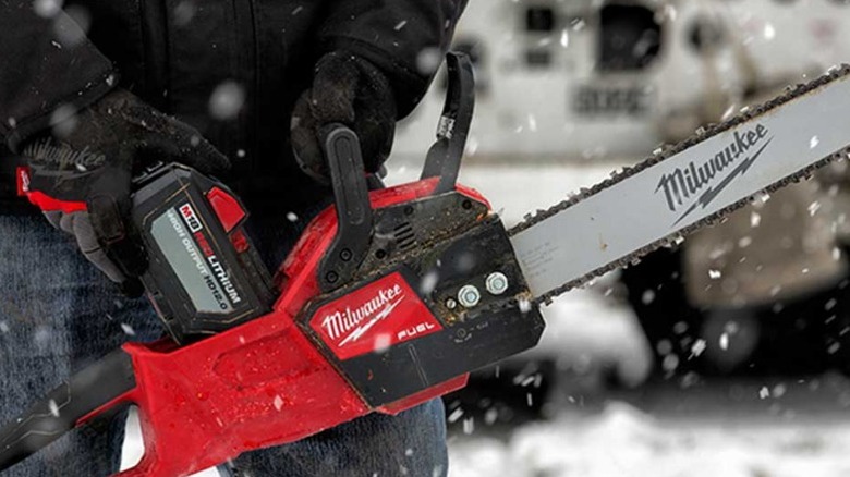 Person holding a Milwaukee M18 Fuel 2727-80 16-inch Chainsaw in the snow