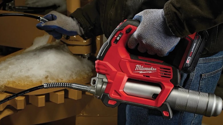 Person using Milwaukee M18 Grease Gun
