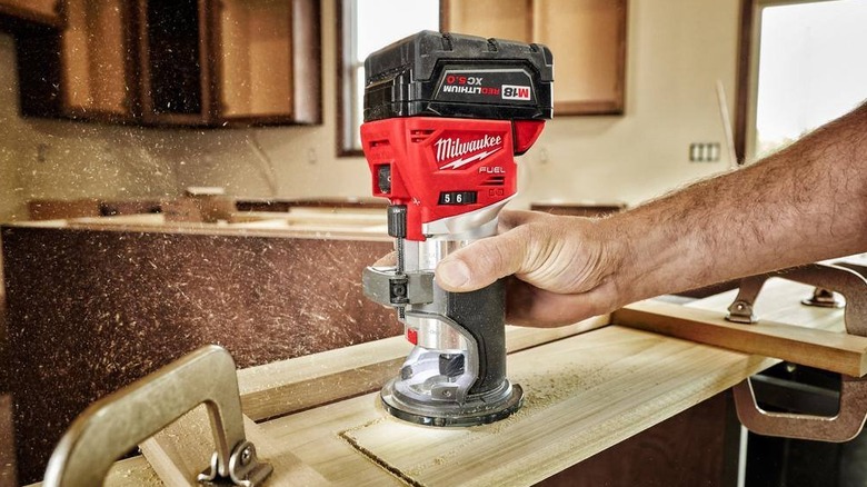 Person using Milwaukee compact router