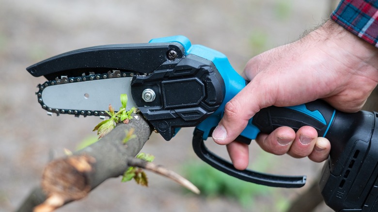 Small handheld chainsaw in use