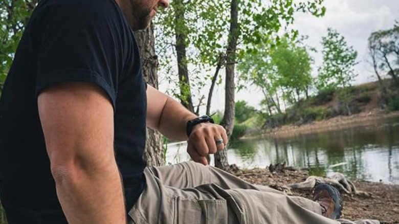 man looking at paracord bracelet