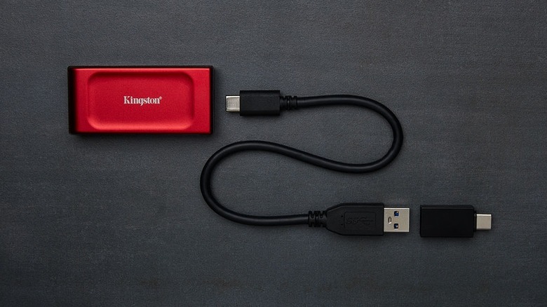 Red Kingston XS1000 on table with USB cable and adapter