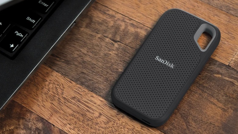 SanDisk Extreme Go on wooden table next to laptop