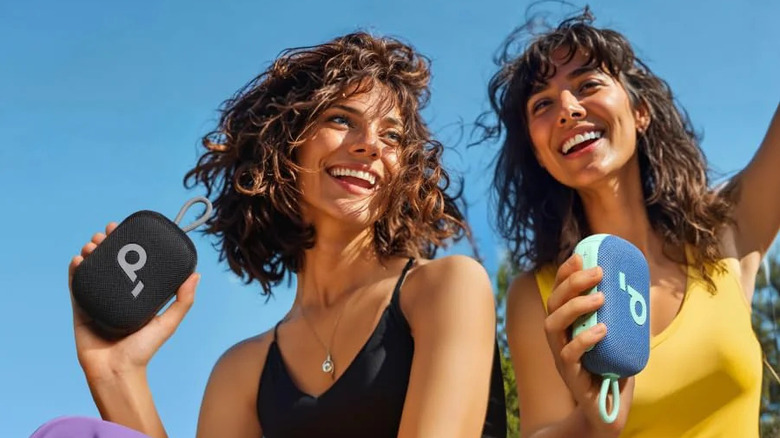 Two women holding Soundcore Select 4 Go speakers outdoors