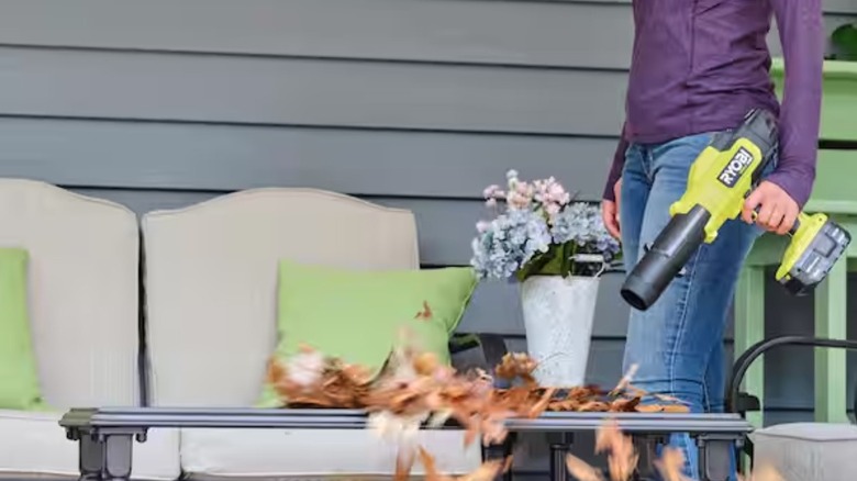 Person installing battery on miniature Ryobi blower