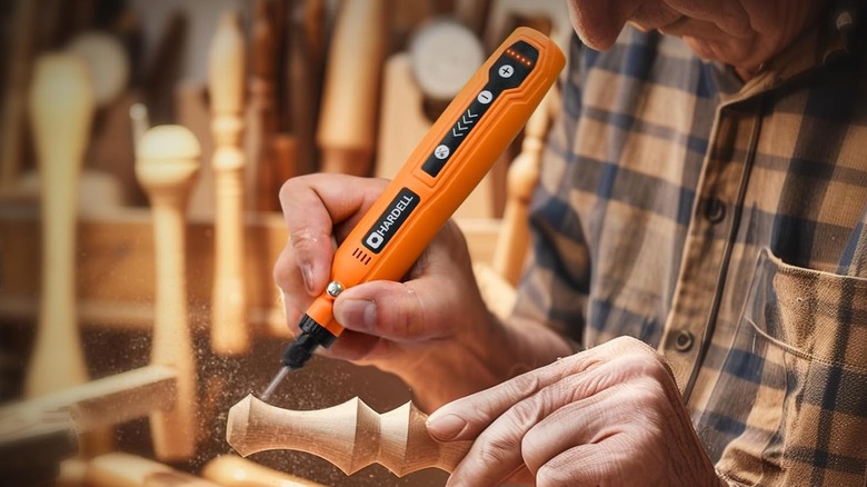 A man using a Hardell mini cordless rotary tool to perform delicate work on a wood carving.