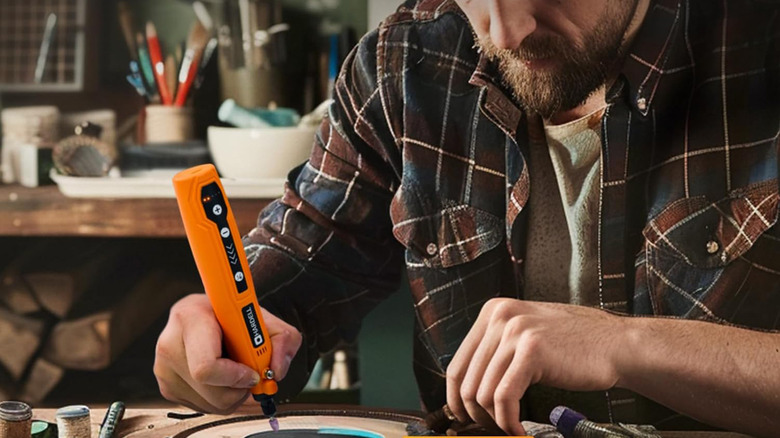 Man using a mini rotary tool on a delicate project.