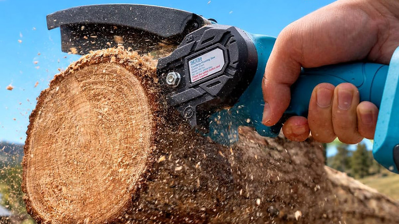Seesii mini chainsaw cutting through a log.
