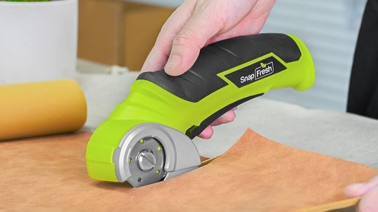 SnapFresh electric scissors being used to cut through a thick material.