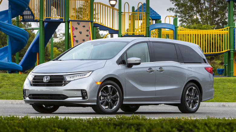 Front 3/4 view of silver Honda Odyssey parked in front of playground.