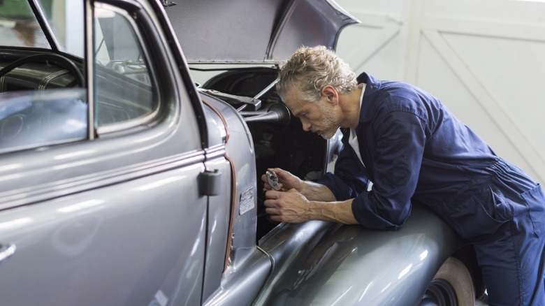 mechanic inspecting a classic car