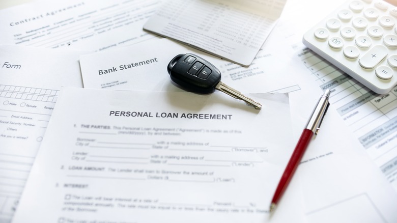 Car keys on top of a personal loan agreement.