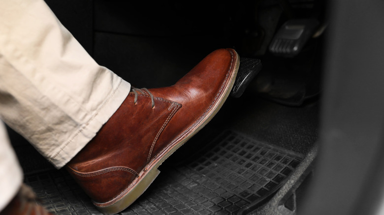 Close-up of driver depressing brake pedal with left foot