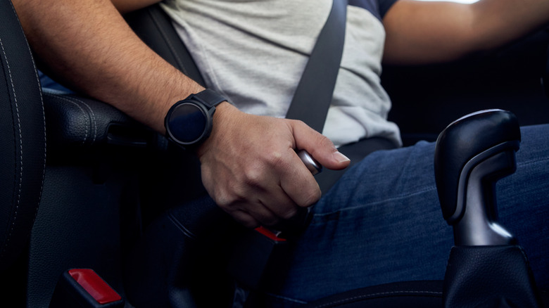 Close-up of driver actuating manual handbrake lever