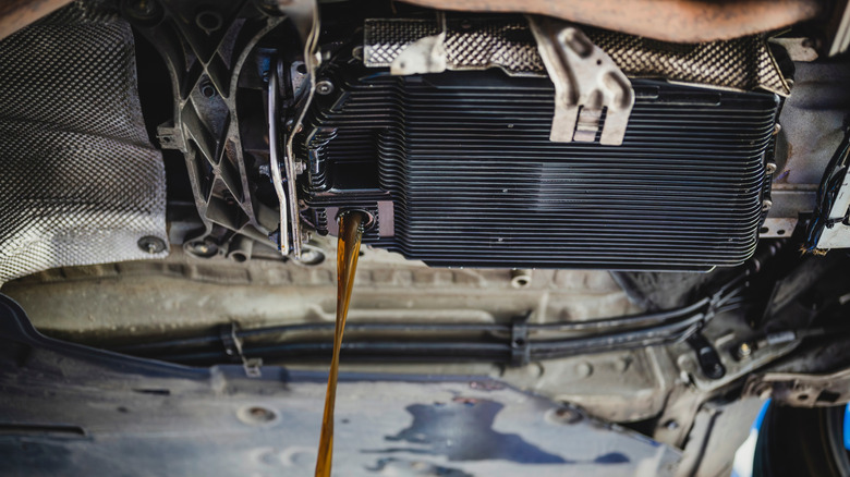 Used transmission fluid pouring out of fluid reservoir during transmission service