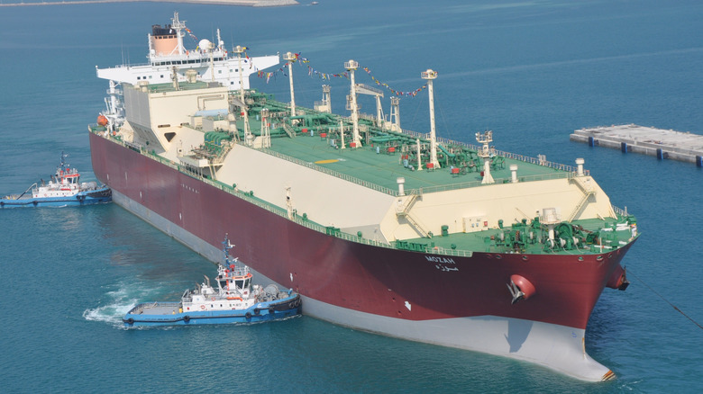The Mozah LNG carrier being maneuvered by tugs