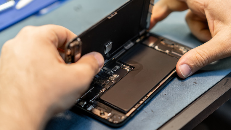 A person opening the back of a smartphone
