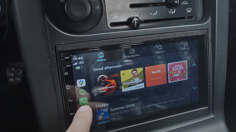 Aftermarket CarPlay screen in a 1990s Mazda
