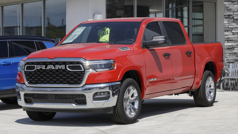 A red and chrome Ram 1500 parked in front of a dealership.