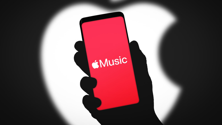 Apple Music logo on smartphone with Apple logo blurred in background