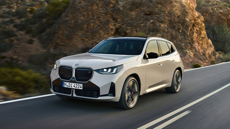 A cream 2025 BMW X3 driving