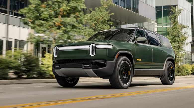 Green Rivia R1S SUV seen from left front on city street