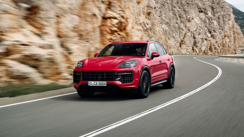 Red 2024 Porsche Cayenne GTS SUV seen from front left on winding mountain road