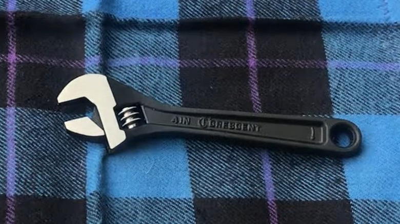 adjustable wrench on a blue plaid background