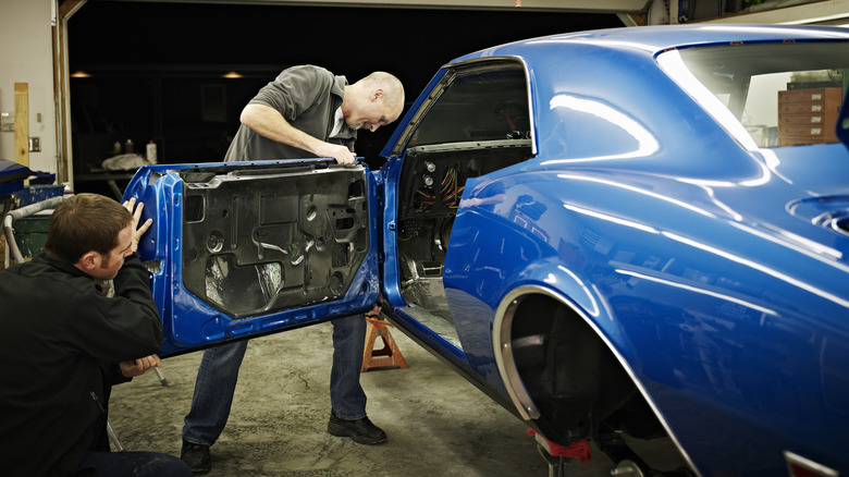 Two men working on a project car in a garage