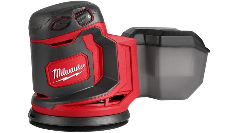 A Milwaukee random orbit sander with a dust canister on a white background