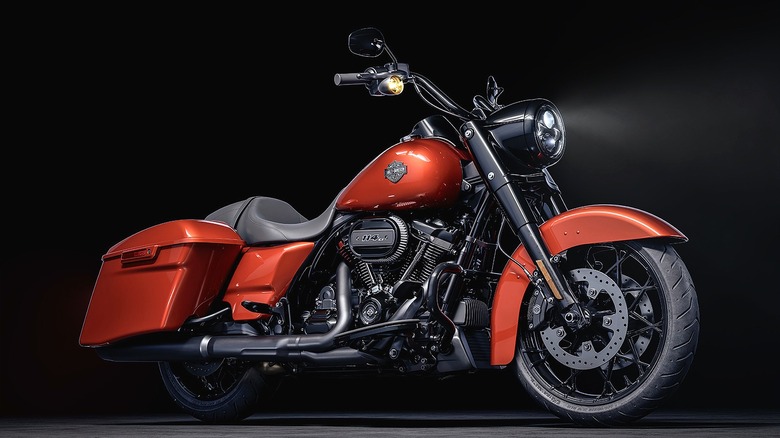 A 2025 brown Harley-Davidson Road King Special showcased dramatically under low light, emphasizing its powerful stance and chrome detailing.
